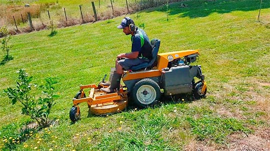 Professional operator mowing large lawns with a ride-on mower